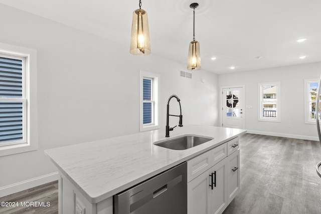 kitchen featuring sink, white cabinets, pendant lighting, an island with sink, and dishwashing machine