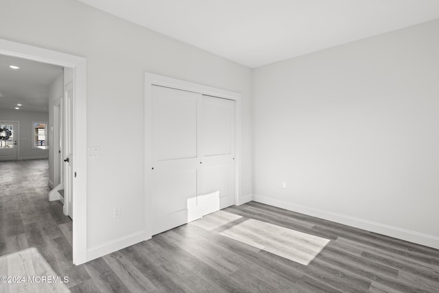 unfurnished bedroom with a closet and dark hardwood / wood-style floors