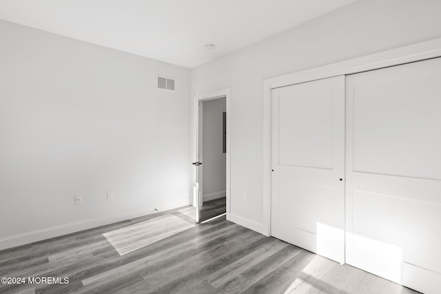 unfurnished bedroom with wood-type flooring and a closet