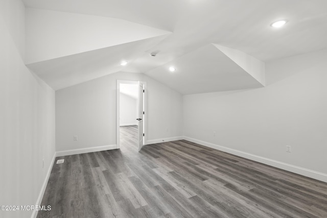 additional living space with vaulted ceiling and dark hardwood / wood-style floors