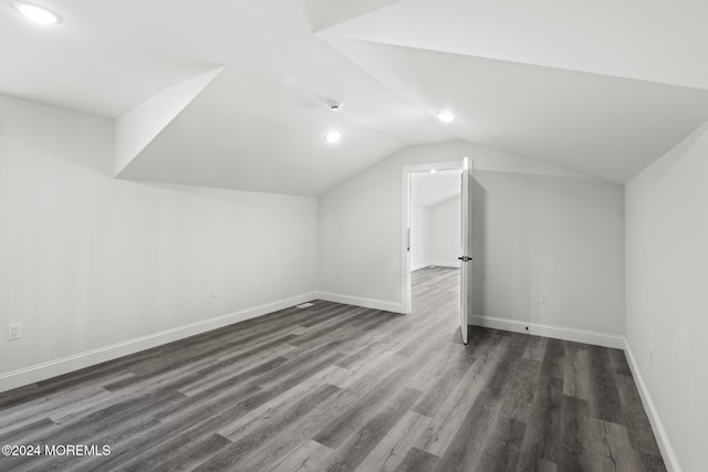 additional living space with dark wood-type flooring and lofted ceiling