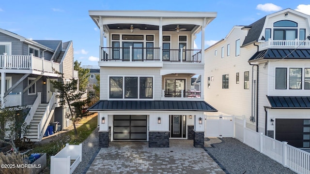 coastal inspired home featuring ceiling fan, a garage, and a balcony