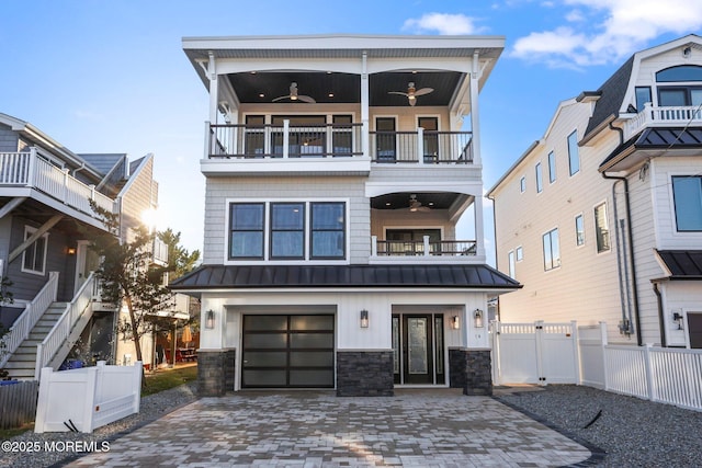 view of front of property with ceiling fan, a garage, and a balcony