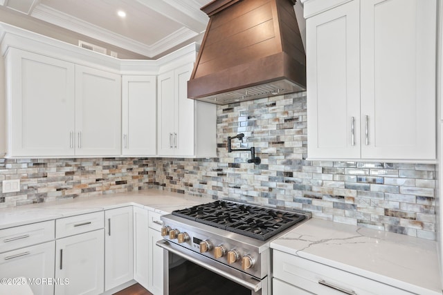 kitchen with white cabinets, premium range hood, and tasteful backsplash