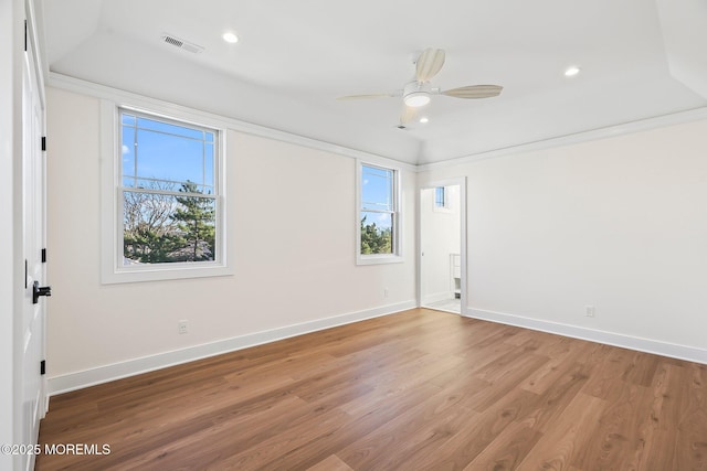 empty room with plenty of natural light, wood-type flooring, and crown molding