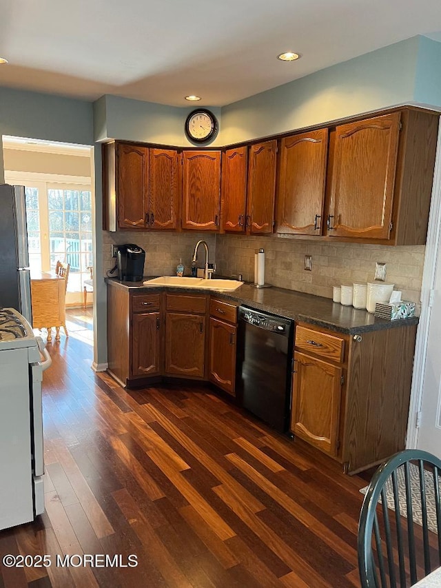 kitchen with stainless steel fridge, stove, dark wood-type flooring, sink, and black dishwasher