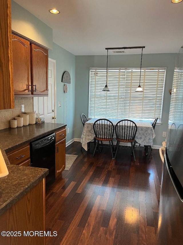 kitchen with decorative backsplash, dark hardwood / wood-style flooring, black dishwasher, and hanging light fixtures