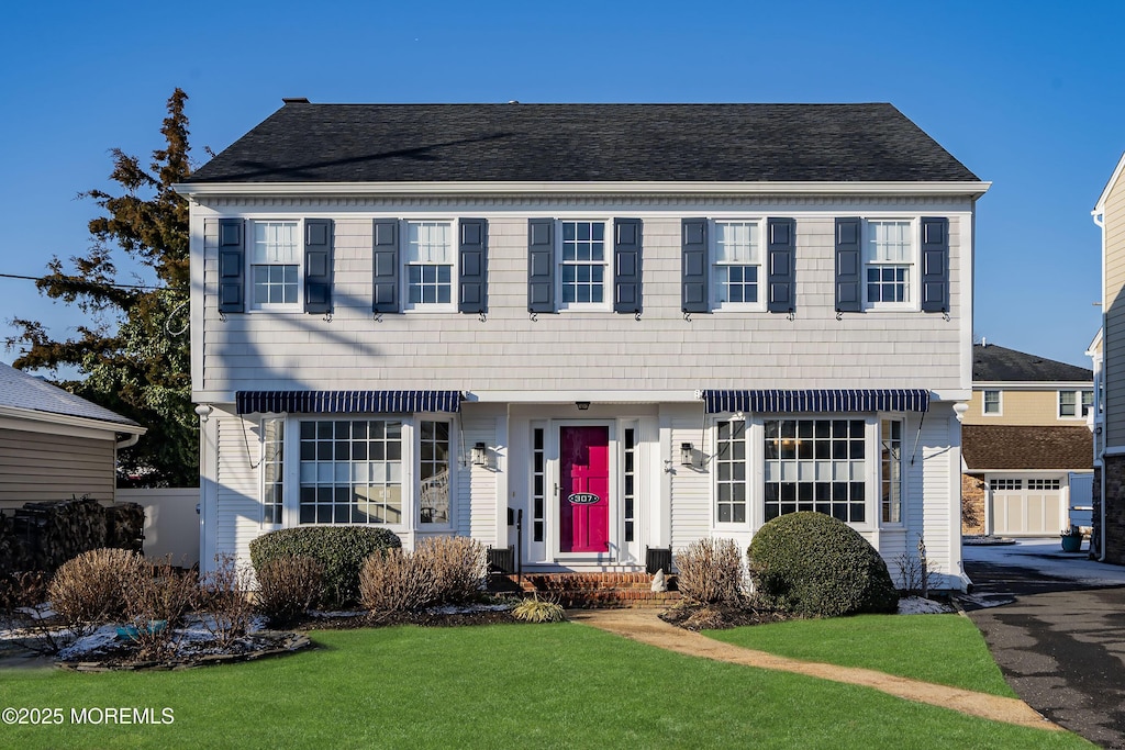 colonial home with a front lawn