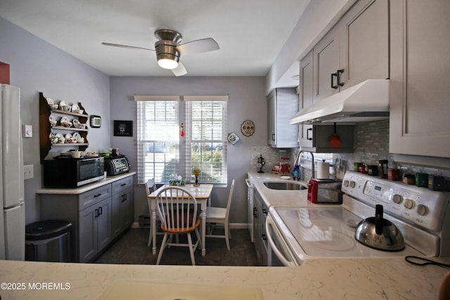 kitchen featuring electric stove, sink, refrigerator, gray cabinets, and decorative backsplash