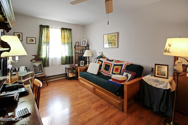 living room with hardwood / wood-style flooring, a baseboard radiator, and ceiling fan