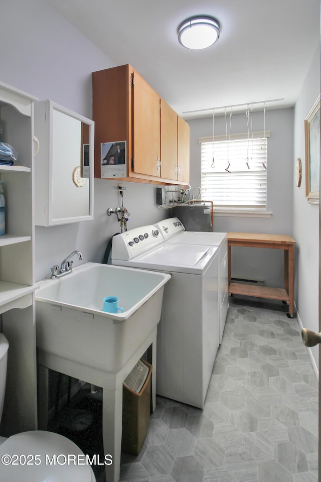 washroom featuring cabinets, water heater, and washing machine and clothes dryer