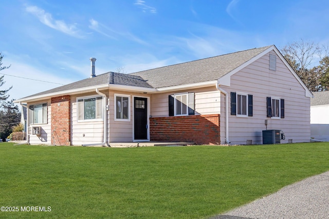 ranch-style home with cooling unit and a front lawn