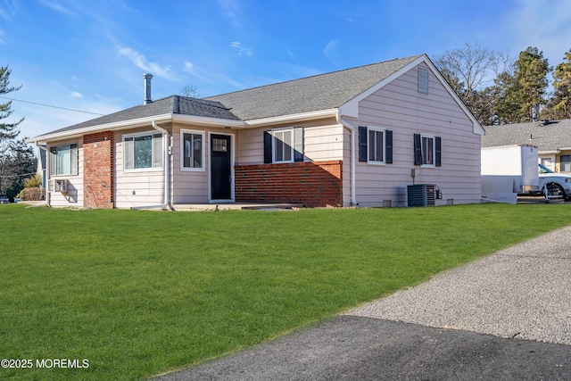 single story home featuring central air condition unit and a front lawn