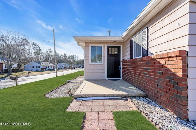 view of exterior entry with a lawn