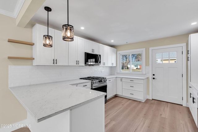 kitchen with stainless steel appliances, white cabinets, pendant lighting, and kitchen peninsula