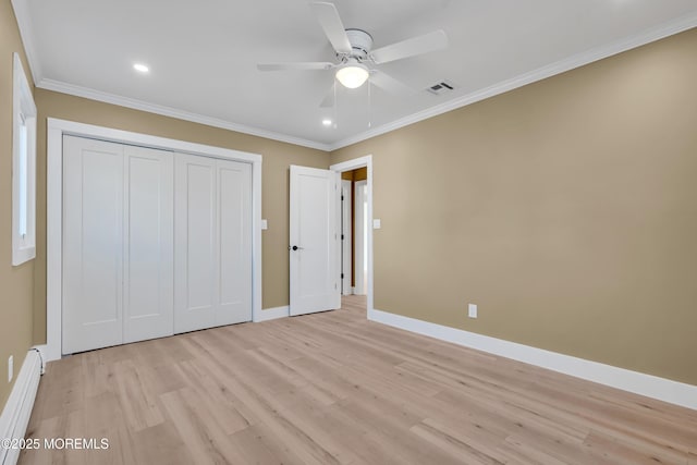 unfurnished bedroom with baseboard heating, a closet, light wood-type flooring, ceiling fan, and ornamental molding