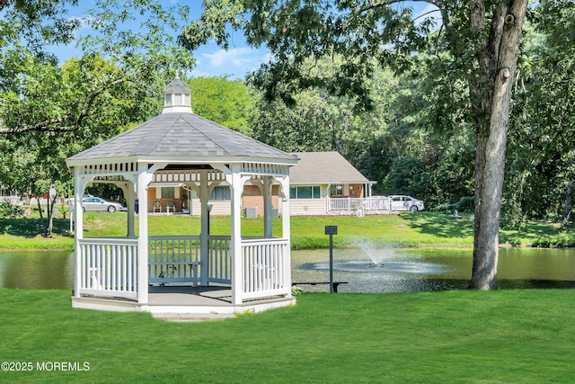 view of property's community with a gazebo, a yard, and a water view