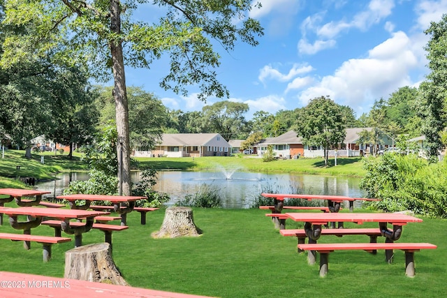 view of community featuring a lawn and a water view