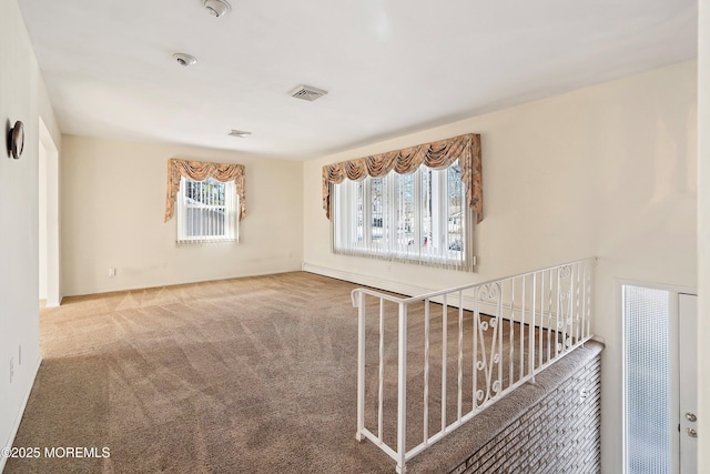 carpeted spare room featuring a healthy amount of sunlight