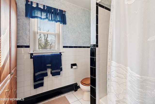 bathroom with tile patterned flooring, toilet, tile walls, and walk in shower