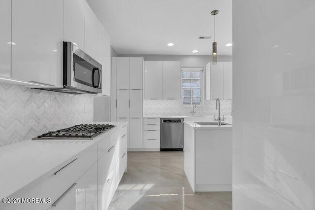 kitchen with white cabinets, stainless steel appliances, pendant lighting, and sink