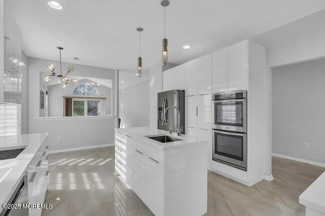 kitchen with white cabinets, hanging light fixtures, appliances with stainless steel finishes, and sink