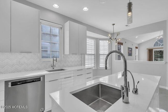 kitchen with sink, decorative light fixtures, white cabinetry, and stainless steel dishwasher