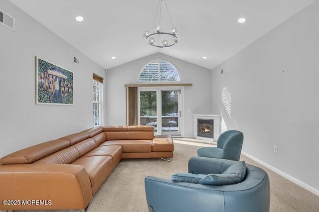 living room with light carpet, a notable chandelier, and vaulted ceiling