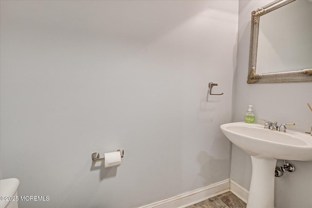 bathroom with hardwood / wood-style flooring and toilet