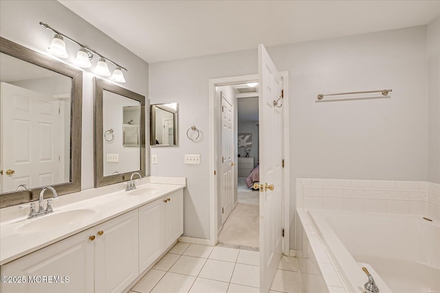 bathroom with tile patterned floors, vanity, and tiled bath