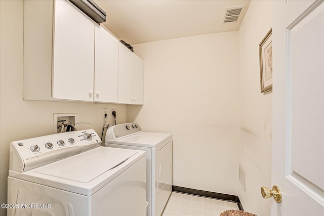 laundry room featuring washer and clothes dryer and cabinets