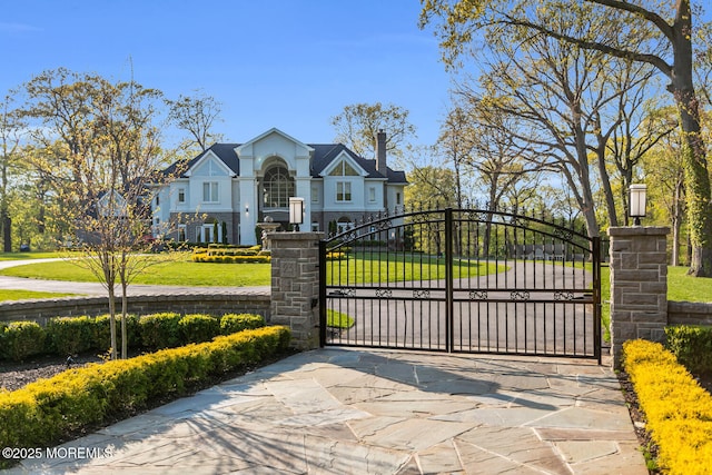 view of gate with a lawn