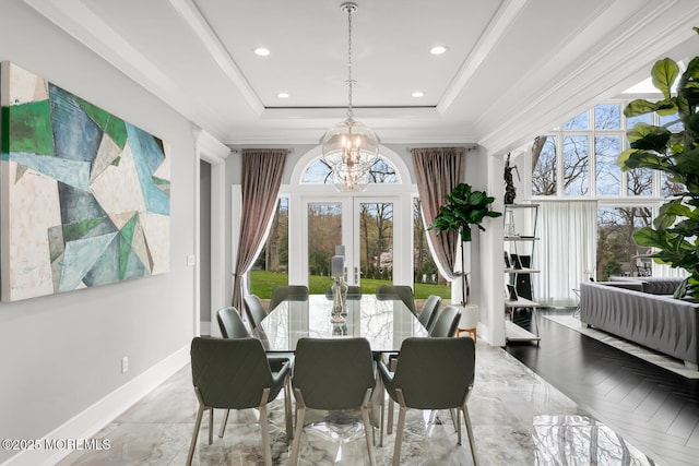 dining room with a tray ceiling, crown molding, french doors, and an inviting chandelier