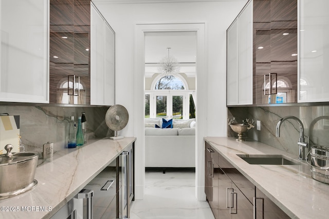 bar with tasteful backsplash, light stone counters, and sink