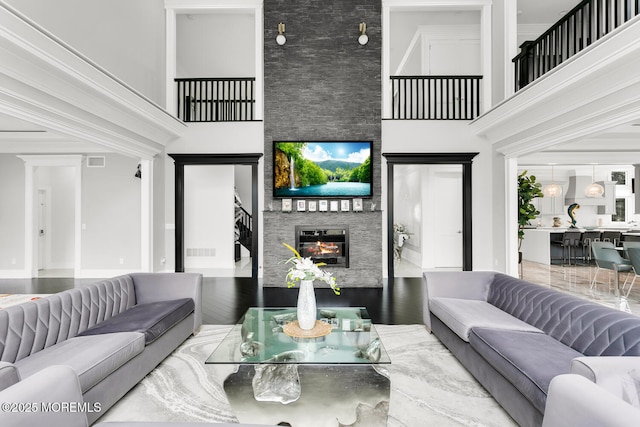 living room with a towering ceiling and a fireplace