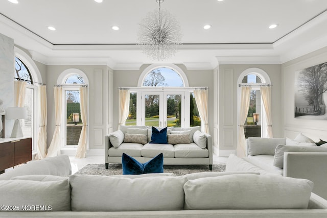 living room featuring a notable chandelier, crown molding, and french doors