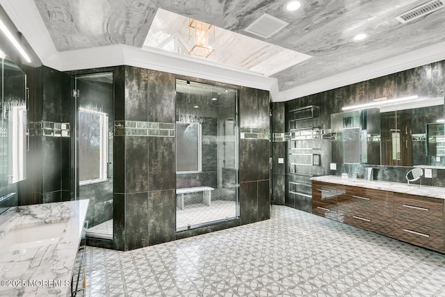 bathroom with vanity, ornamental molding, tile walls, and walk in shower