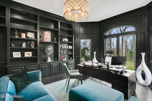 office space with built in shelves, dark hardwood / wood-style flooring, and an inviting chandelier