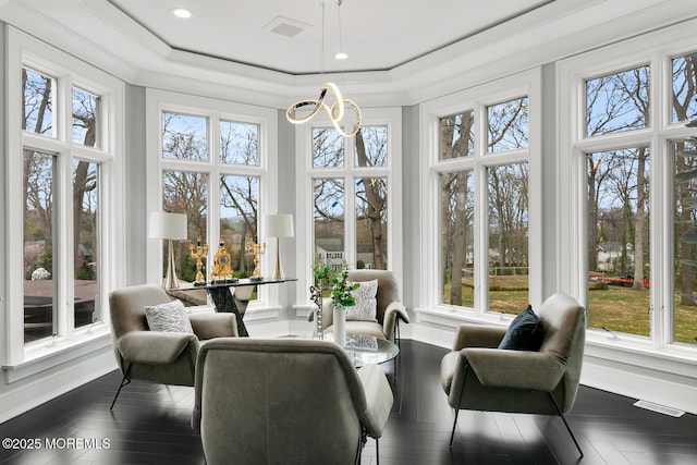 sunroom featuring plenty of natural light and a raised ceiling