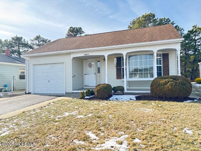 ranch-style house featuring a garage and a front lawn