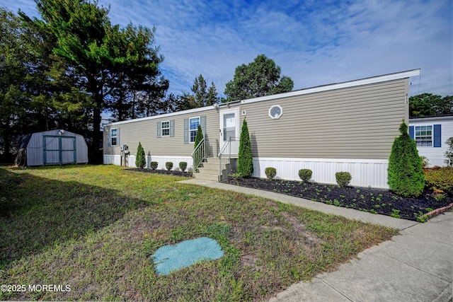 view of front of home featuring a front yard and a storage shed