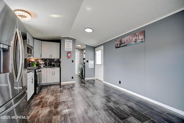 kitchen with white cabinetry, decorative backsplash, stainless steel appliances, and lofted ceiling