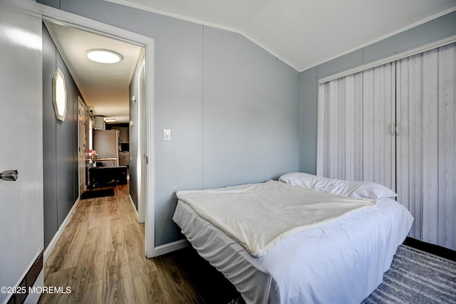 bedroom with crown molding, dark wood-type flooring, and lofted ceiling