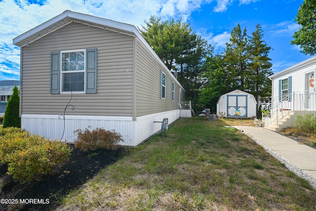 view of side of property featuring a lawn and a storage unit