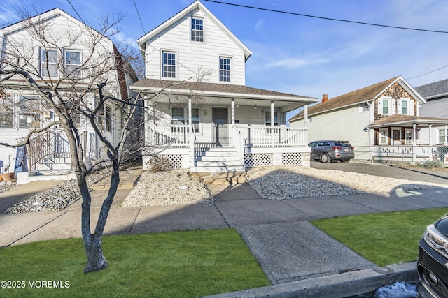 country-style home featuring covered porch and a front lawn