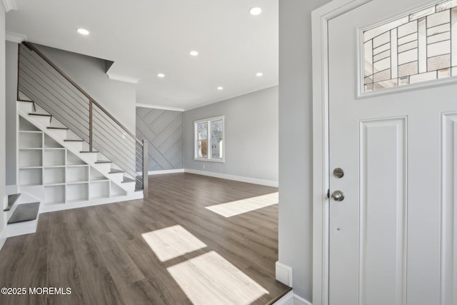 entrance foyer with ornamental molding and dark wood-type flooring