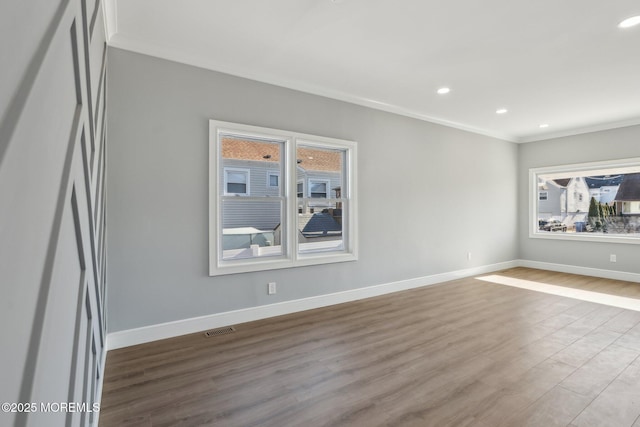 spare room with light hardwood / wood-style floors and crown molding