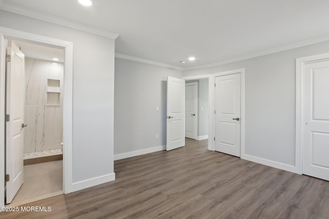 unfurnished bedroom with hardwood / wood-style floors, connected bathroom, and ornamental molding