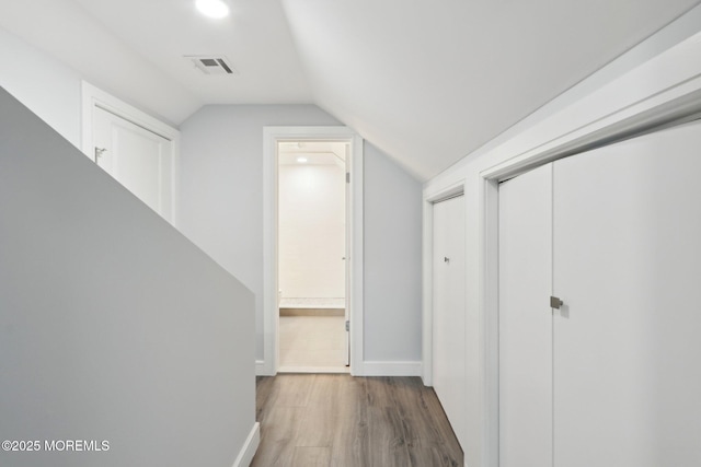 hall with lofted ceiling and dark hardwood / wood-style floors