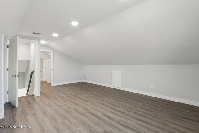 additional living space featuring light hardwood / wood-style flooring and lofted ceiling